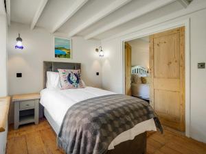 a bedroom with a large bed and a door at Alma Cottage in Solva