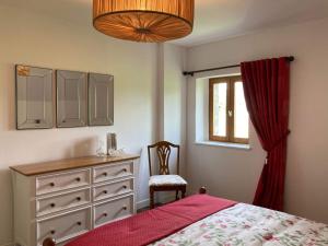 een slaapkamer met een bed, een dressoir en een raam bij Gîte des Pommiers in Le Fresne-Poret