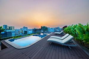 a rooftop deck with a swimming pool and a sunvisor at DHTS Business Hotel & Apartment in Ho Chi Minh City