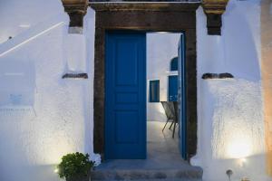 a blue door on a white building with a stairs at Mary Castelia Villa with Jacuzzi in Akrotiri