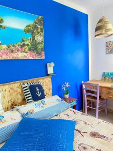 een blauwe slaapkamer met een bed en een bureau bij Blu Airport Room Fiumicino in Fiumicino