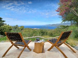 - deux chaises et une table avec vue sur l'océan dans l'établissement U Castellu Chambres d'hôtes & Location villa et appartements vue mer, à Propriano