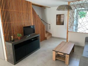 a living room with a tv and a wooden table at Maison avec cour privative in Luz-Saint-Sauveur