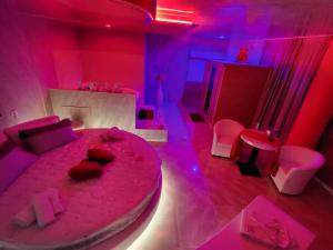 una camera con un grande letto rosa e luci rosa di B&B Luxury Room & SPA a Apricena