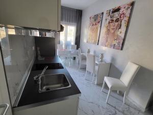 una cucina con lavandino, tavolo e sedie di B&B Luxury Room & SPA a Apricena