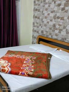 a bed with a colorful blanket on top of it at OYO Home Tawi View Home in Jammu