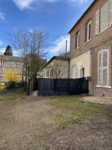 um quintal vazio em frente a uma casa de tijolos em Le Duplex em Louviers