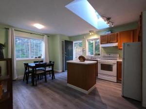 uma cozinha com uma mesa e cadeiras e um frigorífico em Countryroad Cozy 2Bedrooms suite2 em Nanaimo