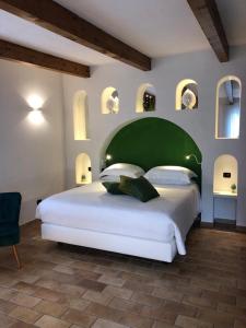 a bedroom with a large white bed with a green headboard at Chalet Claudia in Sant'Agnello
