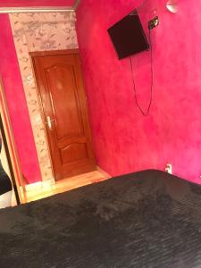 MilanG في مدريد: غرفة بجدار احمر فيها باب وتلفزيون