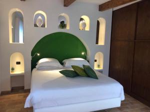 a bedroom with a large bed with a green headboard at Chalet Claudia in Sant'Agnello