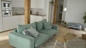 a living room with a blue couch and a kitchen at MODERNO Y LUMINOSO EN EL CENTRO DE SANTANDER in Santander