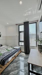 a bedroom with two beds and a large window at Nhà nghỉ IZUMI Phương Trang in Vung Tau