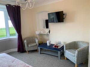 Habitación con 2 sillas, mesa y TV. en "Room only" at Wetherby Nairn en Nairn