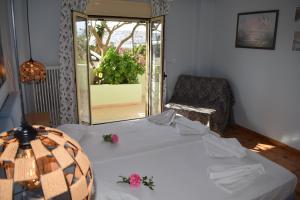 a bedroom with a bed and a chair and a window at Bellevue Apartments in Sitia