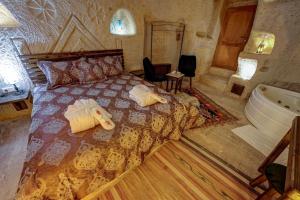 um quarto com uma cama e uma banheira em Cappadocia Alaz Cave Otel em Nevşehir