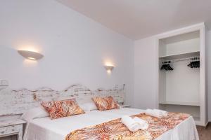 um quarto branco com 2 camas e toalhas em Sol Parc Hotel & Apartments em Son Parc