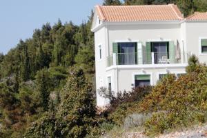 a white house on a hill with trees at Porto Katsiki Blu in Athani