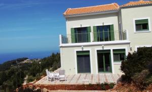 a house on a hill with two chairs on a deck at Porto Katsiki Blu in Athani