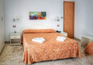 a bedroom with a bed and two night stands at Hotel Pineta in San Menaio