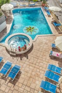 an overhead view of a swimming pool with blue chairs and a pool table at Hotel Pineta in San Menaio