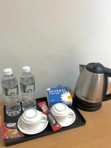 a tray with cups and plates and a coffee maker at Hotel Premier Inn (Prima Square) in Sandakan