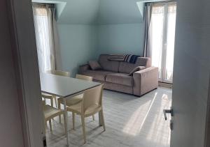 sala de estar con sofá, mesa y sillas en La Magnolia Apartaments IV, en Desenzano del Garda