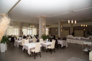 a dining room with white tables and chairs at Hotel Umberto in Rosolina Mare
