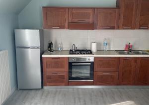 cocina con armarios de madera y nevera de acero inoxidable en La Magnolia Apartaments IV, en Desenzano del Garda