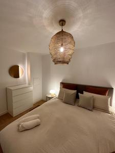 sypialnia z dużym białym łóżkiem z żyrandolem w obiekcie Cosy Apartment / Disneyland / Val d'Europe w mieście Serris