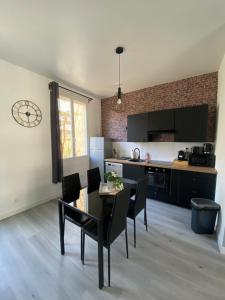 uma cozinha e sala de jantar com mesa e cadeiras em Le Duplex em Louviers
