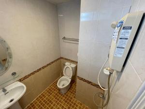 a small bathroom with a toilet and a sink at Man u Apartment in Chaiyaphum