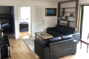 uma sala de estar com um sofá de couro e uma mesa de centro em Coastal Hideaway - Venus Bay (1st Estate) em Venus Bay