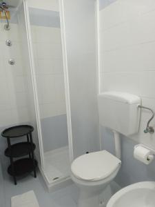 uma casa de banho branca com um WC e um chuveiro em B&B Scogli Bianchi em Noto Marina