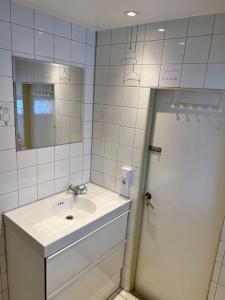a white bathroom with a sink and a mirror at Längtan Marielund in Uppsala