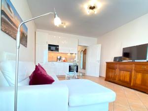 ein Wohnzimmer mit einem weißen Sofa und einem TV in der Unterkunft Villa Jasmin App. 1 in Heringsdorf