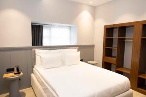 - une chambre avec un lit blanc et une étagère dans l'établissement Royal Hayat Hotel Old Town, à Antalya