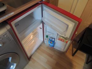 a small refrigerator with its door open in a kitchen at Burns Cottage in Dalleagles