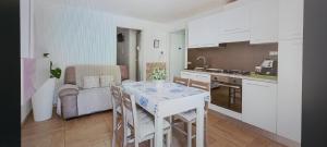 a kitchen and living room with a table and chairs at ORISTANO CAMERA BLU max 2 pers, BAGNO E USO CUCINA in Oristano