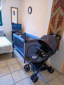 Un cochecito de bebé sentado en una habitación con cuna en Derveni Seaside Apartments "Groundfloor", en Derveni