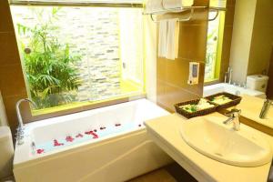 a bathroom with a tub and a sink and a window at Ánh Dương Hotel Hải Phòng in An Khê