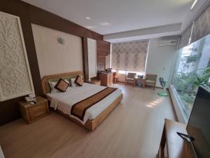 a hotel room with a bed and a desk at Ánh Dương Hotel Hải Phòng in An Khê +16 photos