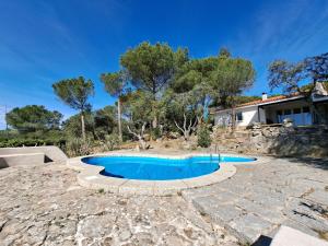 a swimming pool with a stone patio and a house at Chalet con piscina en Torrelodones in Torrelodones