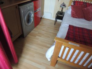 a room with a bed and a washing machine at Burns Cottage in Dalleagles