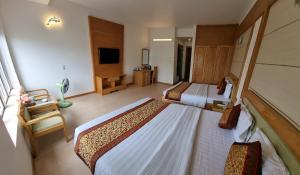 a hotel room with two beds and a television at Ánh Dương Hotel Hải Phòng in An Khê
