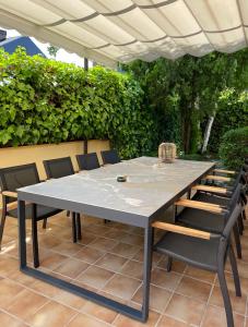 una mesa y sillas bajo una sombrilla en un patio en Moderna Casa de Lujo con Jardín y Barbacoa en Madrid