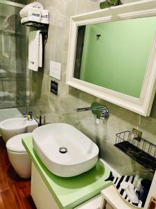 bagno con lavandino, servizi igienici e specchio di RarityArt GuestHouse a Salerno