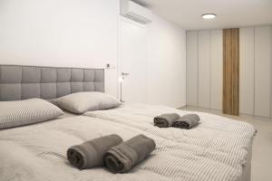 a bedroom with a large bed with two pillows on it at Brand new apartment with private pool in Njivice +27 photos
