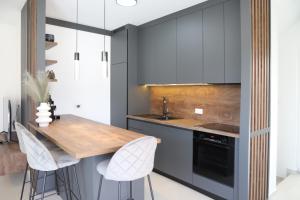 a kitchen with a wooden counter and white cabinets at Brand new apartment with private pool in Njivice