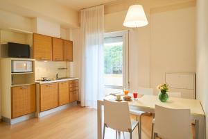 a kitchen and dining room with a table and chairs at Aparthotel La Pineta in Lido di Jesolo